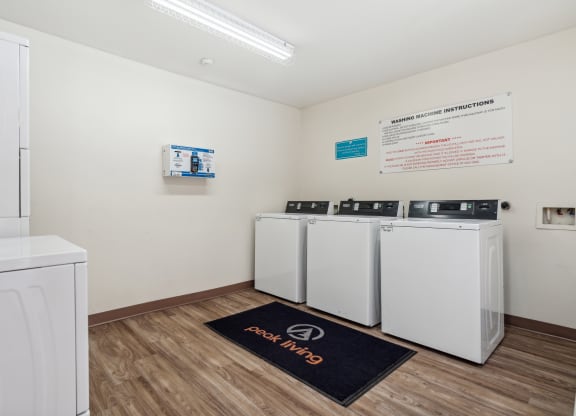 a laundry room with washers and dryers and a row of washing machines