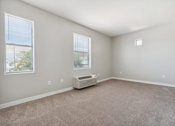A room with a window and a wall-mounted air conditioner.
