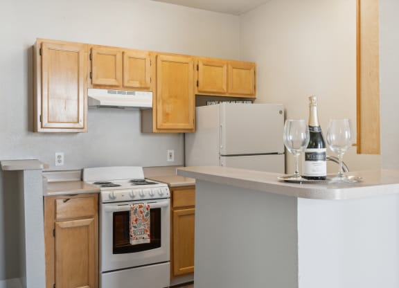 A kitchen with a white stove and wooden cabinets.