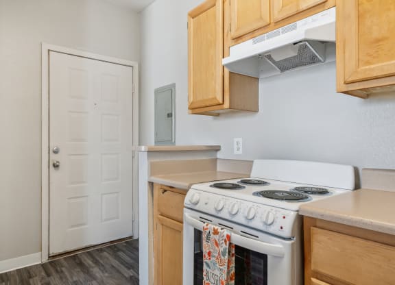 a kitchen with a white stove and a white door