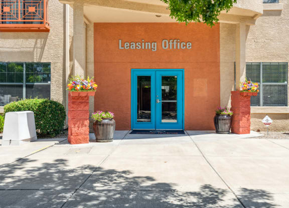 the outside of a leasing office with a blue door