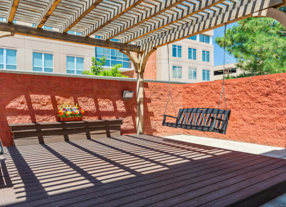 a patio with a bench and a pergola