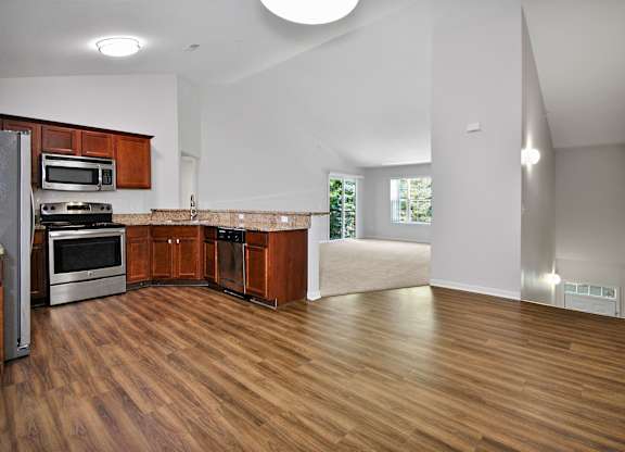 A kitchen with wooden floors and a refrigerator.