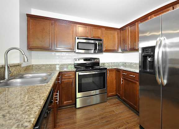 A kitchen with wooden cabinets and stainless steel appliances.