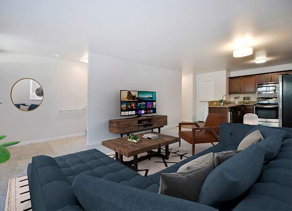 A living room with a grey couch and a wooden coffee table.