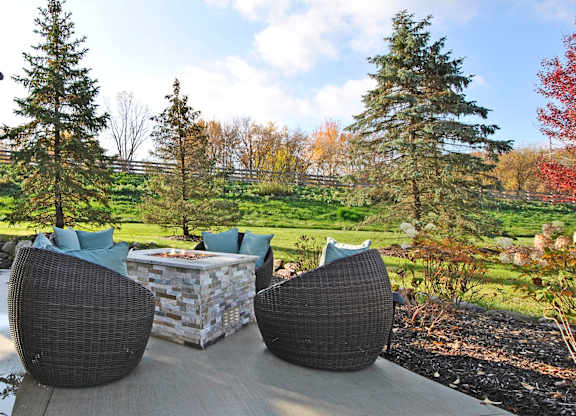 Two chairs and a table are on a patio.