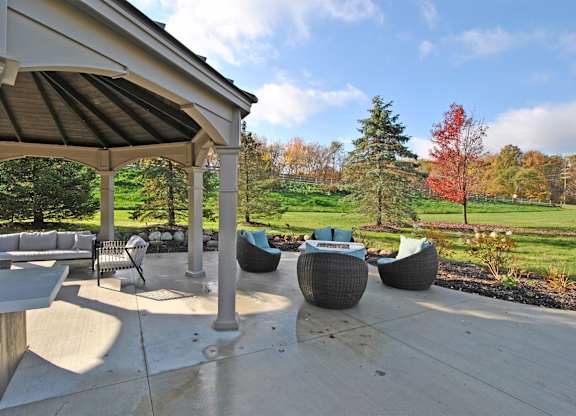 A patio with a table and chairs under a roof.