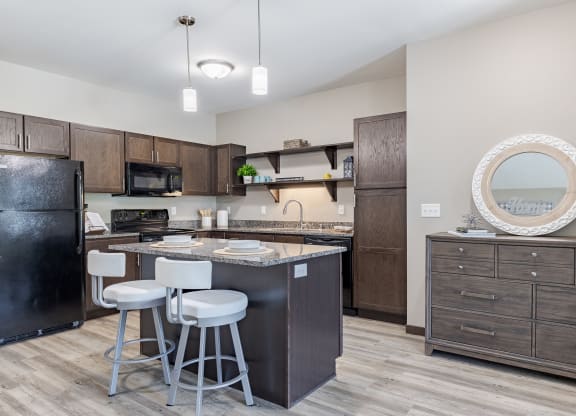 an open kitchen with a bar and stools in front of a counter top