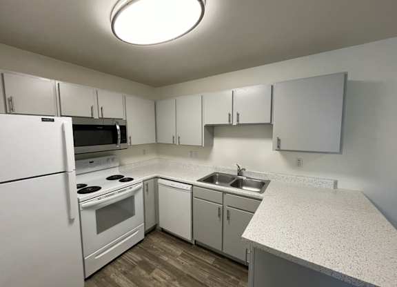 A kitchen with white appliances and cabinets.