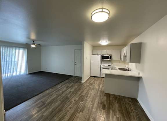 A kitchen area with a sink, refrigerator, and microwave.
