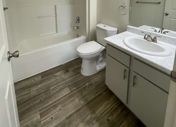A white toilet sits in a bathroom next to a sink.