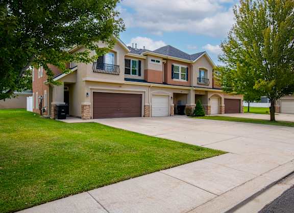 A two-story house with a garage and a driveway.