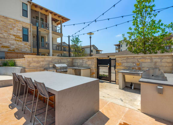 the backyard has a large table with chairs and a barbecue grill