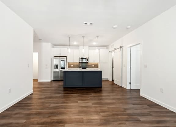 a kitchen with white walls and a black island in the middle of it