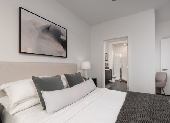a bedroom with a large bed and a painting on the wall