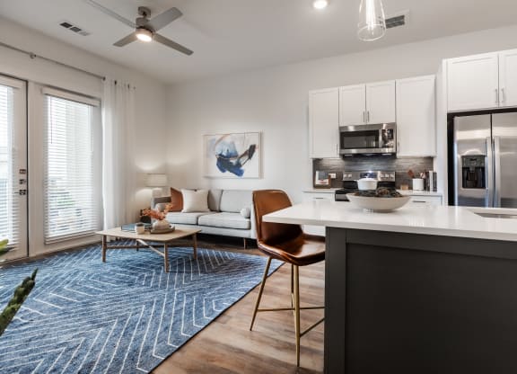 an open living room and kitchen with a refrigerator and a microwave
