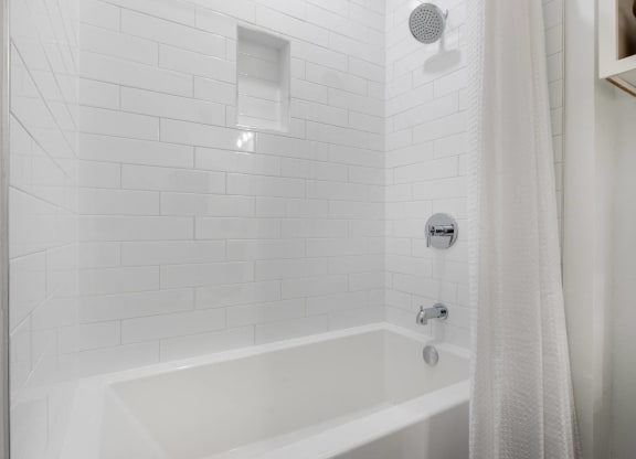 a white bathroom with a shower and a tub