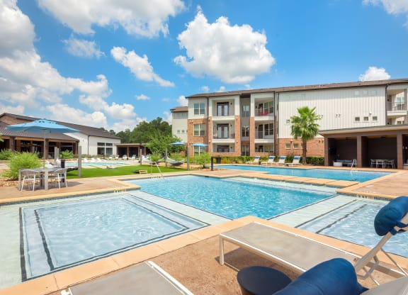 our apartments have a large swimming pool with chairs and umbrellas