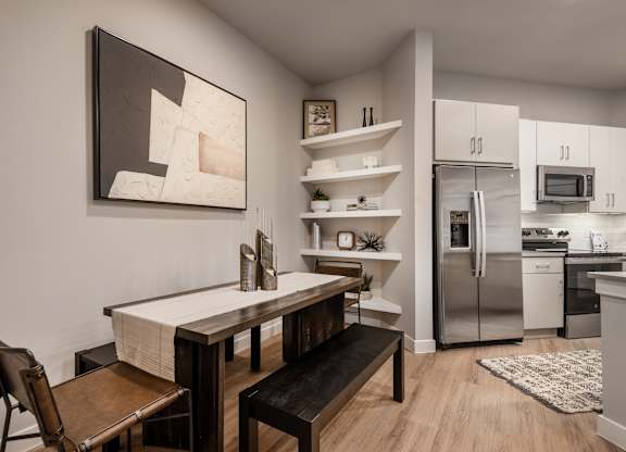 A kitchen with a table and chairs and a painting on the wall.