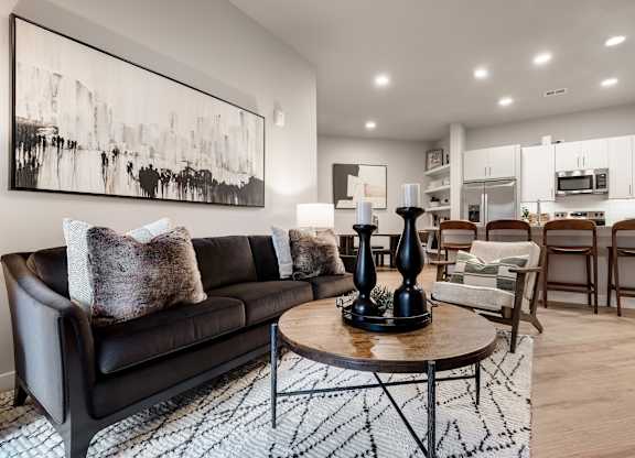 A black leather sofa with a wooden coffee table in front of it.