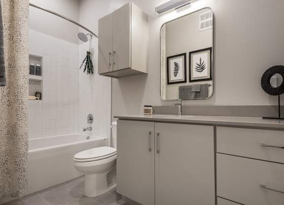 A white bathroom with a toilet, sink, and shower.