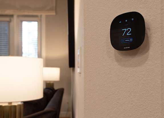 A wall-mounted thermostat shows the temperature as 72 degrees.