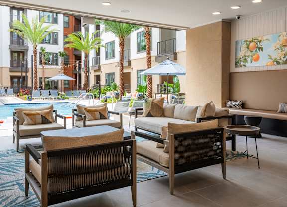 A poolside lounge area with cushioned seating and a view of the pool.