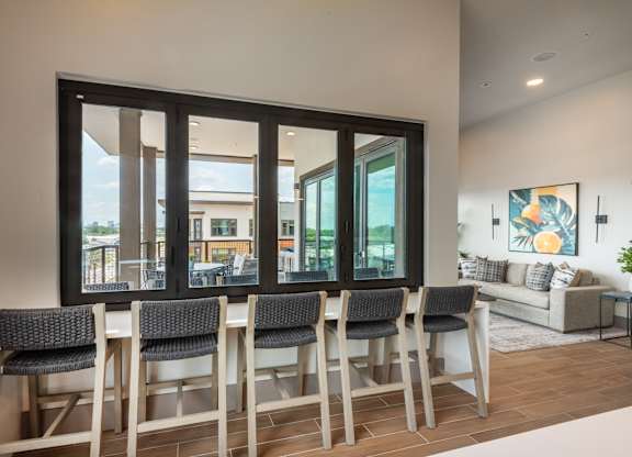 A dining room with a table and chairs in front of a large window.