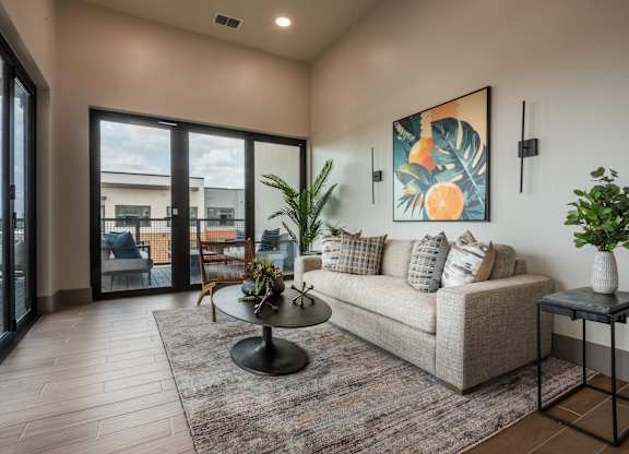 A living room with a couch, a table, and a painting on the wall.