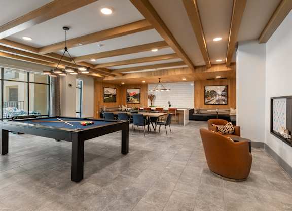 A room with a pool table and a couch.