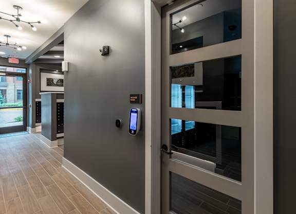 A glass door with a handle and a keypad lock.