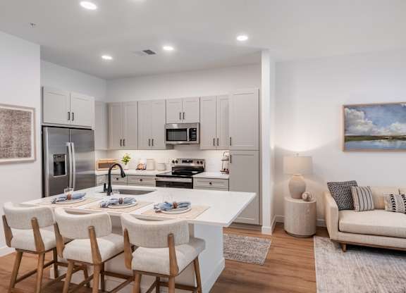 A modern kitchen with a dining table set for four.