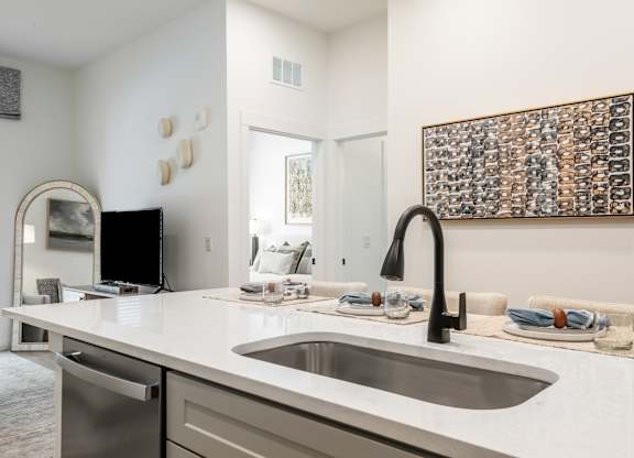A modern kitchen with a large sink and a framed picture on the wall.