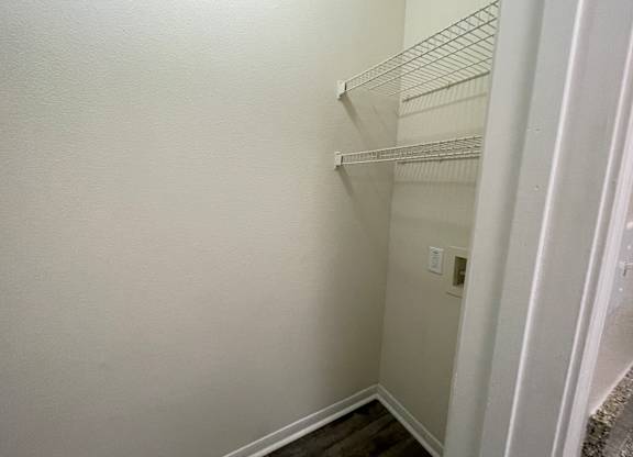 A white wall with a shelf and a switchboard.