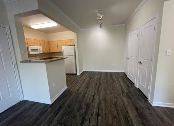 A kitchen area with a microwave, oven, and refrigerator.