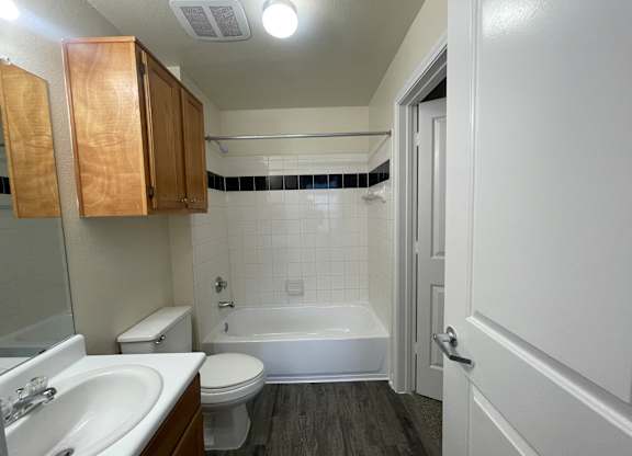 A bathroom with a white toilet, sink, and bathtub.