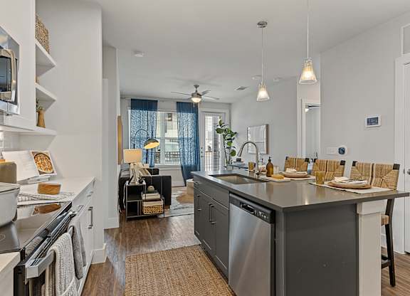 A modern kitchen with a large island and stainless steel appliances.
