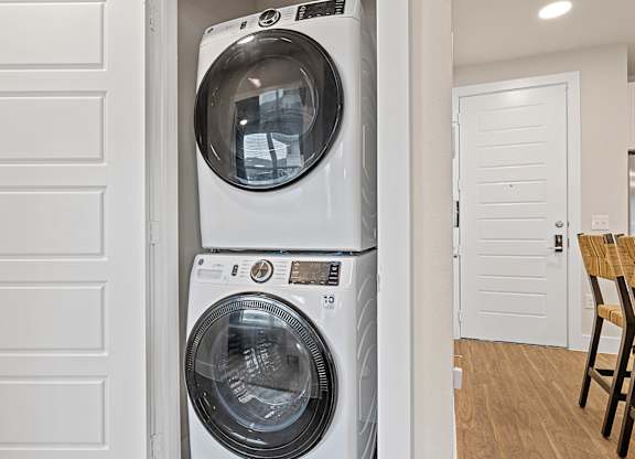 A white front load washing machine in a laundry room.