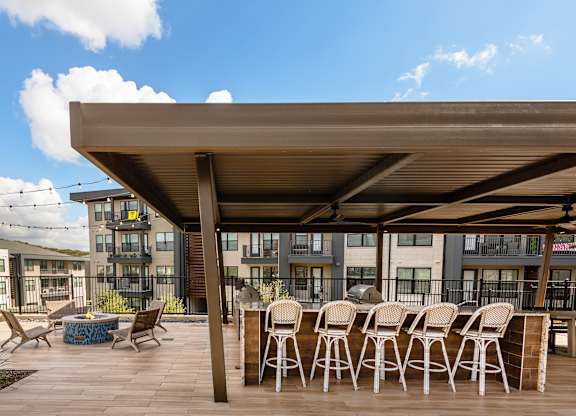 A patio with a table and chairs under a roof.