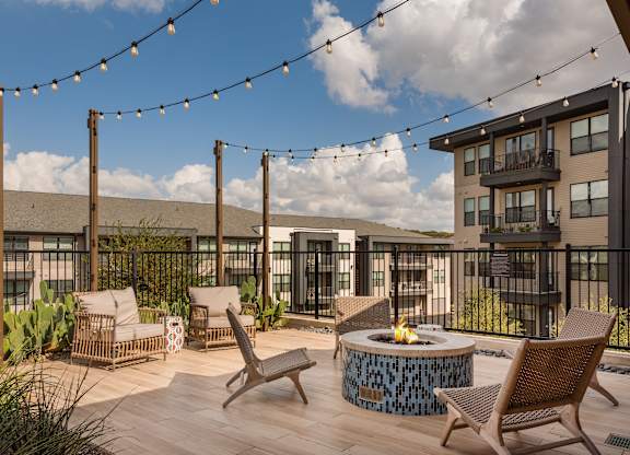 A patio with chairs and a fire pit.