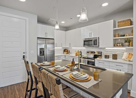 A modern kitchen with a dining table set for two.