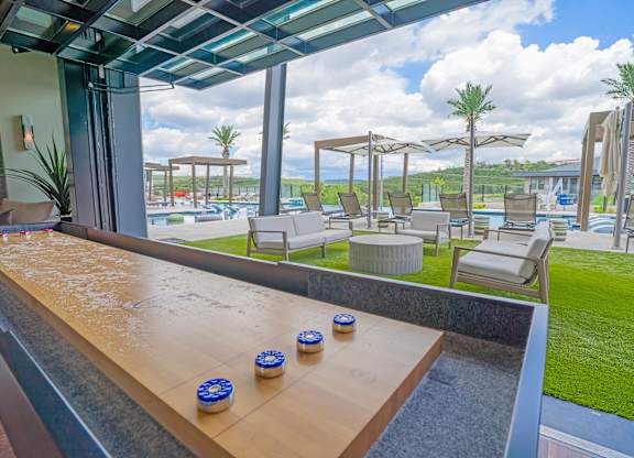 A poolside area with a wooden bench and blue and white objects on it.