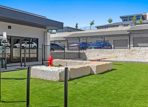 A modern building with a white exterior and a black fence.