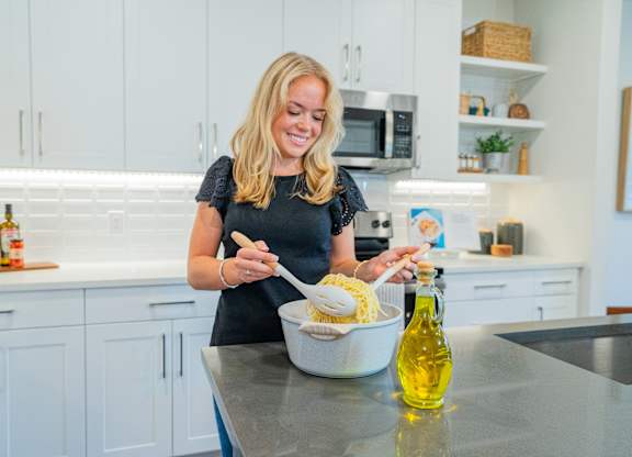 A woman is cooking in a modern kitchen.