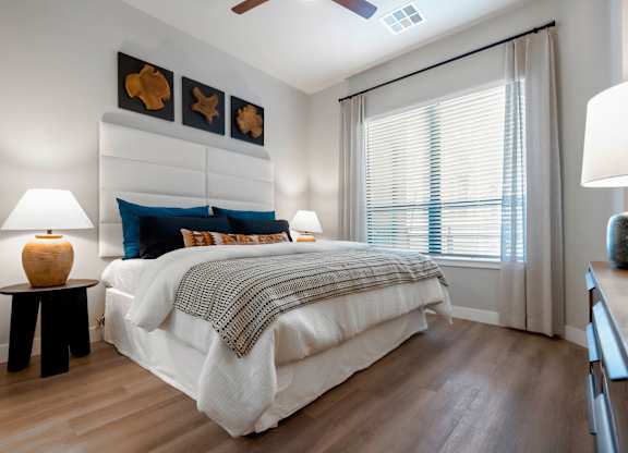 A bedroom with a large bed and a ceiling fan.