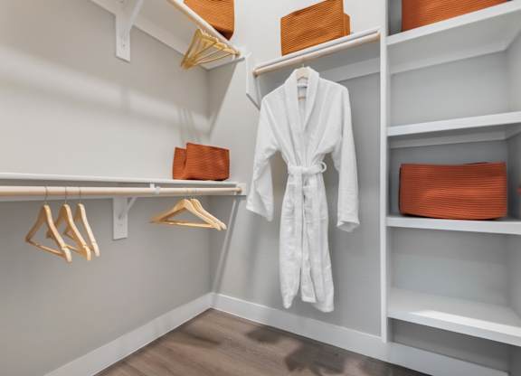 A white robe is hanging on a rack in a room.