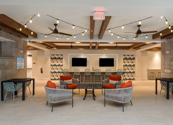 A room with a long table and chairs with a TV on the wall.
