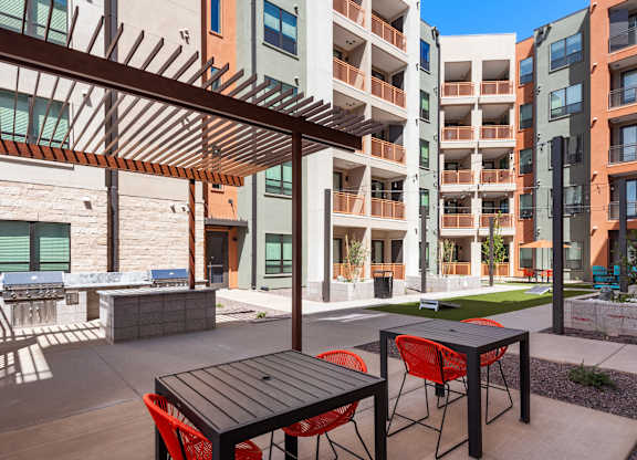 A patio with a table and chairs is in front of a building.