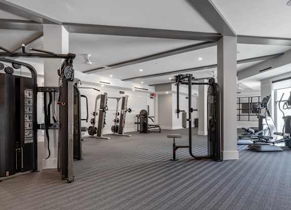 A spacious gym with a variety of equipment including treadmills, weights, and exercise machines.