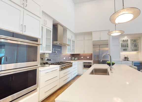 a large kitchen with a white counter top and a sink